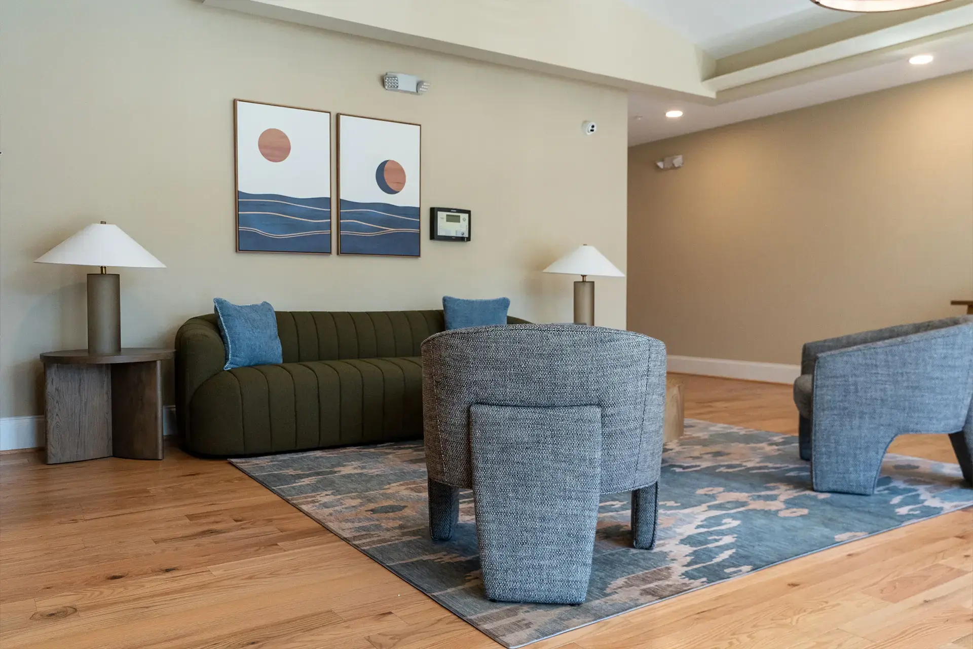 The Abby community area near rear entrance with sofa and single chairs
