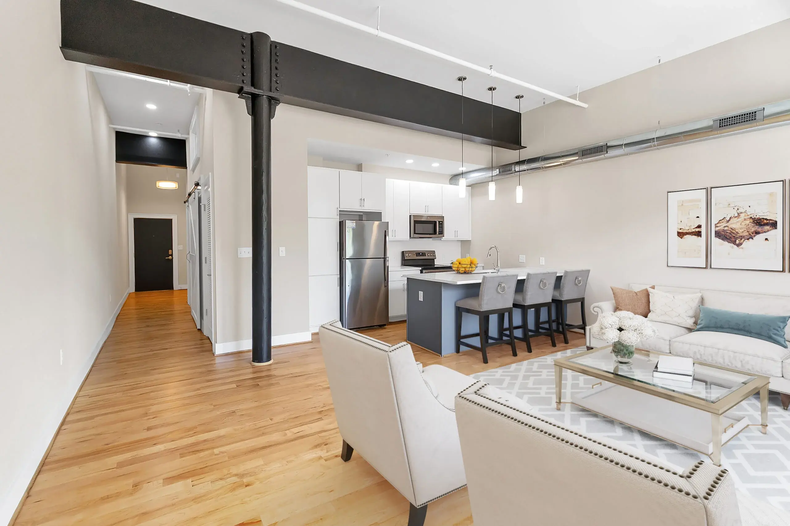 The Watkins condominium living room and kitchen with steel beam