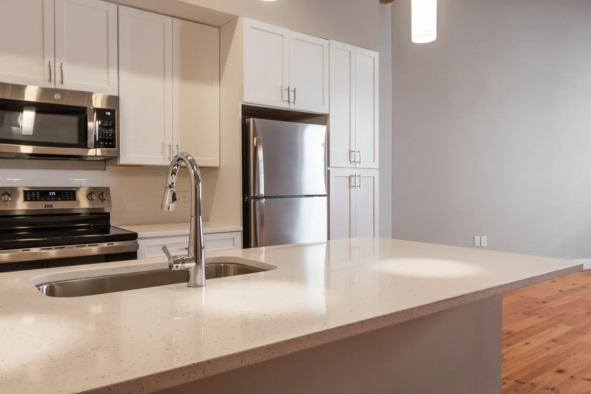 Kitchen with white cabinets and countertops at The Watkins