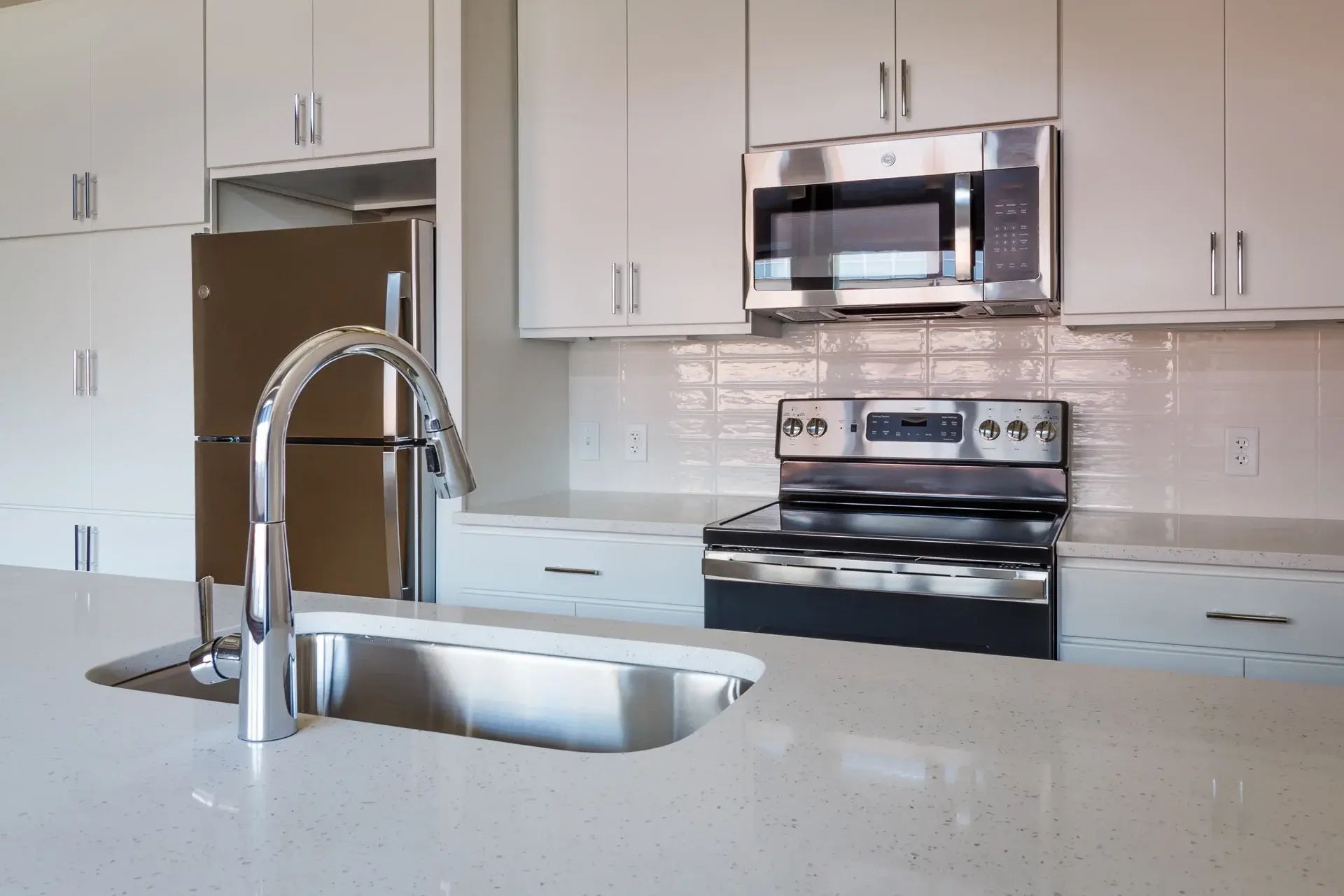 Modern kitchen sink and stainless steel range in condo at The Watkins