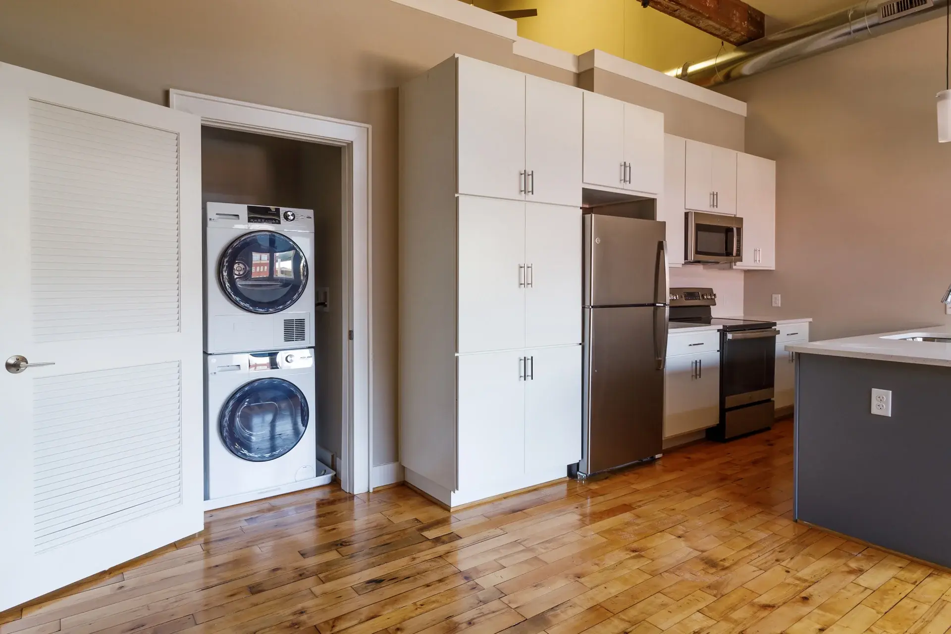 Laundry machines and kitchen in condo at The Watkins