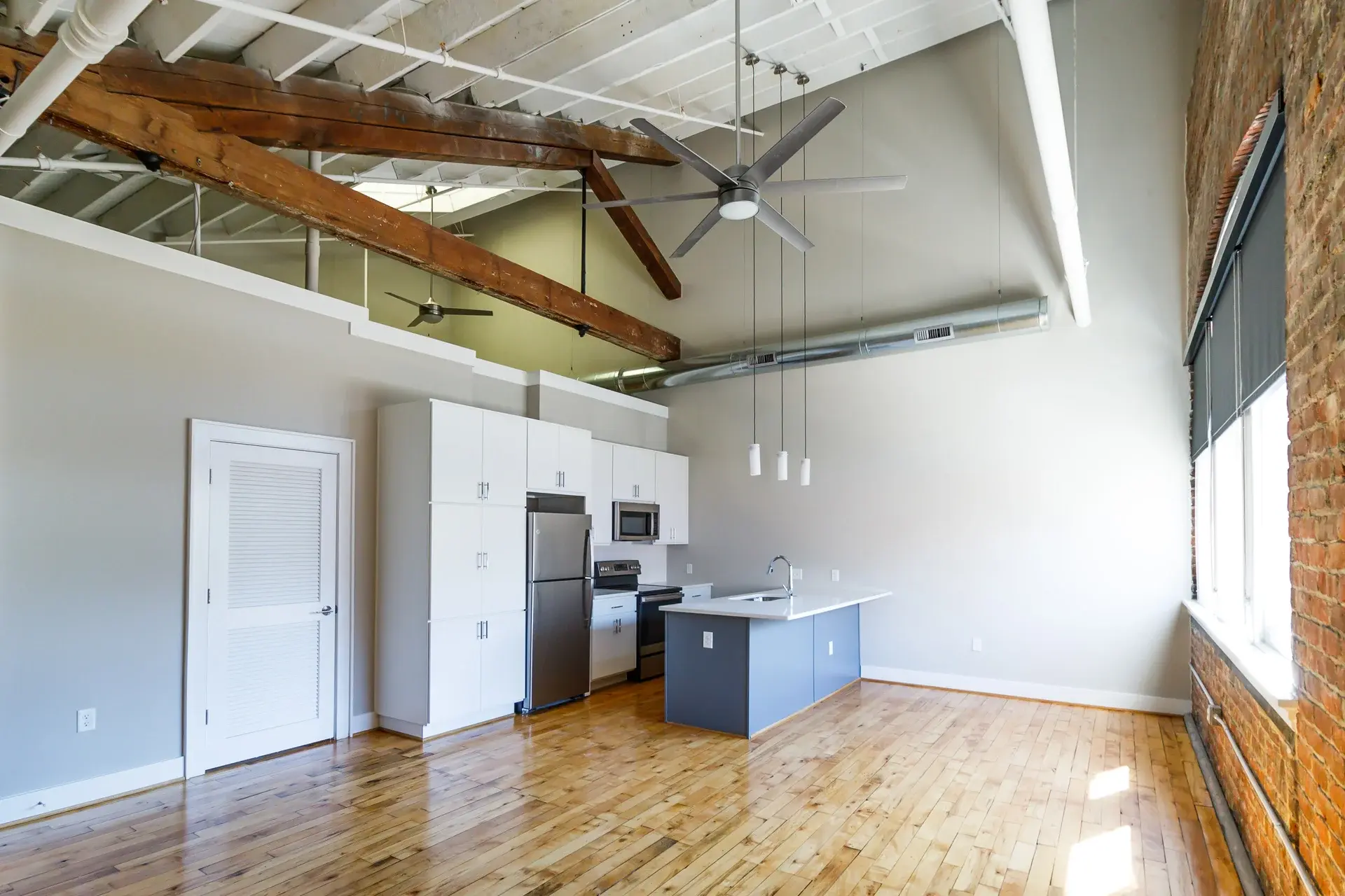Kitchen, hardwood floors, exposed beams in a condo at The Watkins